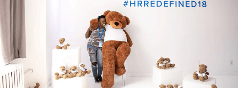An HR Redefined Attendee poses with the Namely Bear